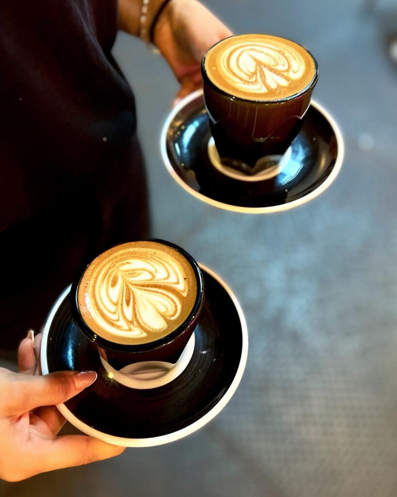 Two beautiful cappuccinos with artfully designed foam art